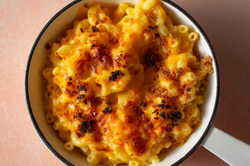 A top down view of a rustic mac n cheese entree in an enameled cast iron skillet.