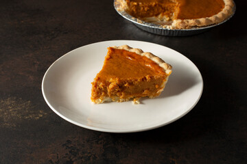 A view of a slice of pumpkin pie, on a plate.