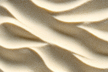 Close-up of sand with wave-like patterns and textures under sunlight