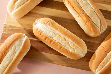 A top down view of a pile of French rolls, on a wood board.