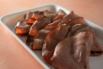 A closeup view of a pile of folded slices of roast beef.