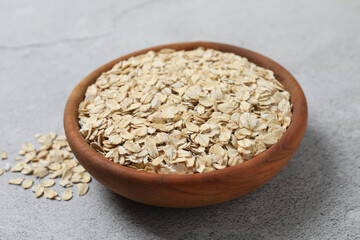 Composition with oatmeal flakes on gray background. Cooking breakfast