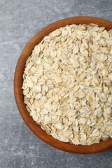 Composition with oatmeal flakes on gray background. Cooking breakfast