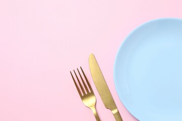 Blue empty plate with cutlery on a colored background