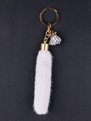 Close up of fur gray ponytail keychain on black background