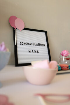 Celebrating new beginnings, table with pastel decorations and congratulatory message, at home