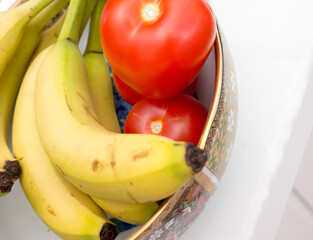 Bananas and tomatoes on a plate.