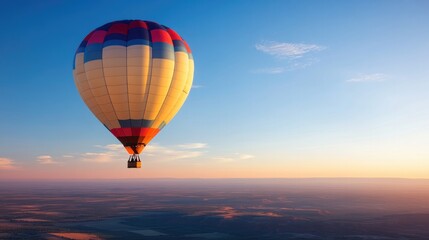 Fototapeta premium vibrant hot air balloon gently soars against serene vast blue sky at sunrise creating spectacle of color and elevation