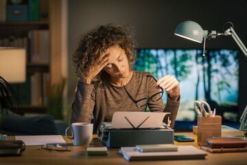Tired woman typing on a typewriter