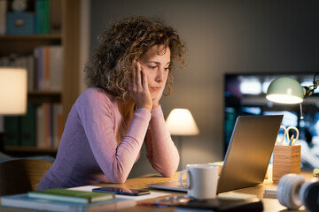 Woman working on her laptop late at night