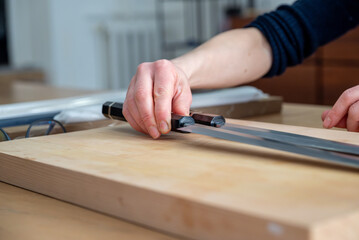 Un artisan professionnel nettoyant et affûtant des couteaux japonais, illustrant son expertise dans le métier de coutellerie traditionnelle.