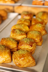 Freshly baked pastries sweet rolls displayed on buffet table in cozy bakery or cafe setting for Breakfast, Brunch and Dessert Lovers Savoring Sweet and Savory Treats