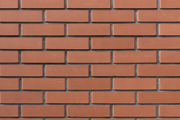 Obraz premium Red brick wall with a classic pattern, creating a strong and industrial look. Perfect for backgrounds, textures, and architectural projects.