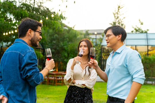 Group of Happy Asian millennial generation people friends enjoy and fun toasting red wine glasses celebration reunion meeting at outdoor dinner party in the garden at restaurant on holiday vacation. - Powered by Adobe