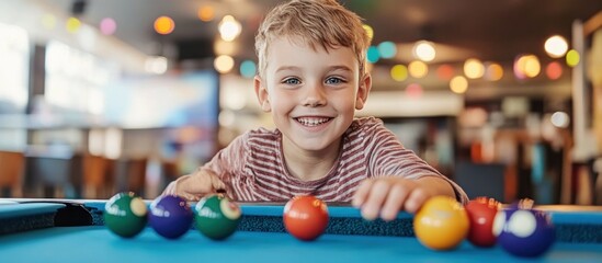 Fototapeta premium Happy boy playing pool in a game room