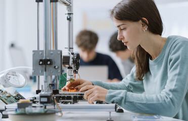 Female student using a 3D printer in the lab