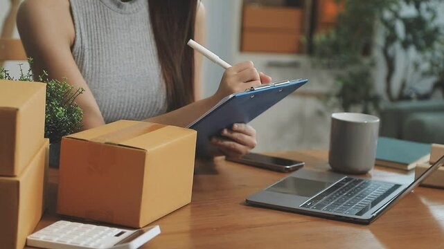 businesswoman start small business and successful SME entrepreneurs asian woman hoding boxs works from home delivering parcels online. SME delivery concept and packaging