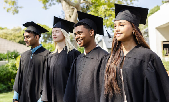 Diverse graduates wearing caps and gowns celebrating academic achievement together in garden