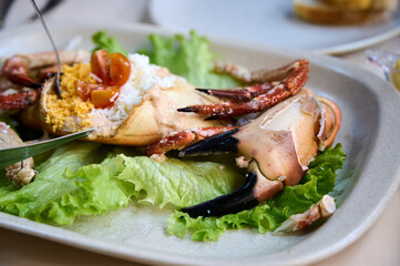 A tasty crab dish with rice and sauce, elegantly served on crisp lettuce at a lively seafood festival.