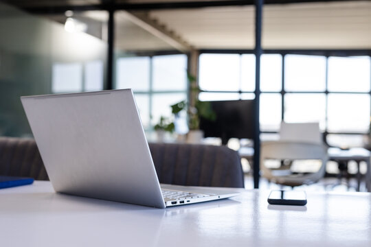 Laptop and smartphone on office desk in modern workspace, ready for business tasks