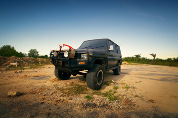 Front view of 4x4 car stopped on a mountain road at sunset. Off-road travel concept. 3D rendering © Image Craft