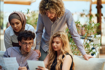 A Diverse MultiEthnic Group Reviewing Projects During a Work Break in a Caffee.
