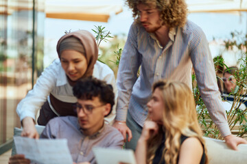 A Diverse MultiEthnic Group Reviewing Projects During a Work Break in a Caffee.