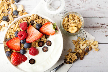 Muesli with organic berries and nuts. Oat muesli with raspberry, blueberry, strawberries, almond, cashew, banana. Healthy food, top view