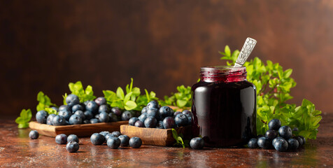 Blueberry jam and fresh berries on a brown background. © Igor Normann