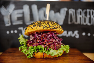 Fresh colorful vegan burgers with vegetables on counter at summer local food market - close up...