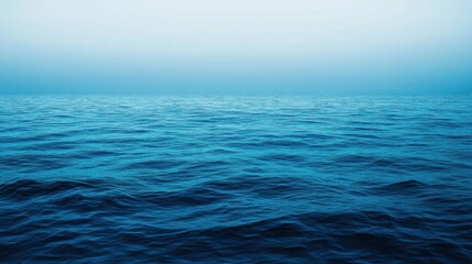 Fototapeta premium Expansive calm blue ocean under a clear sky at dawn captures the serenity of nature's beauty and tranquility