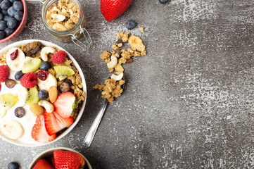 Muesli with organic berries and nuts. Oat muesli with raspberry, blueberry, strawberries, kiwi, almond, cashew, banana. Healthy food, top view