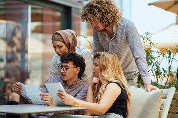 A Diverse MultiEthnic Group Reviewing Projects During a Work Break in a Caffee.