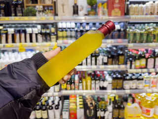 choosing olive oil, sauce, vinegar at the grocery store