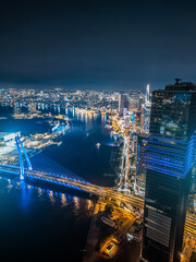 Obraz premium night view of illuminated Ho Chi Minh city skyline and Saigon river, neon street lights of financial downtown district with tall skyscraper towers, Vietnam aerial drone view