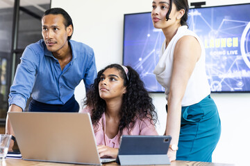 Diverse business team collaborating on project with laptop and tablet in office