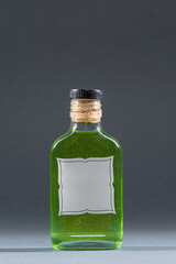 bottle with homemade alcohol tincture or liquor, mockup with empty label, tarragon and peppermint