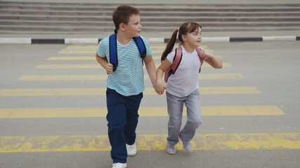 Children crossing the street safely, Kids holding hands on a crosswalk, Schoolchildren on their way to school, Boy and girl walking together, Safe road crossing for kids, Children with backpacks