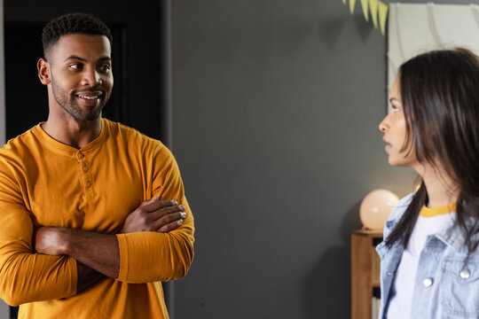 African American man and woman talking at home, both looking engaged and happy