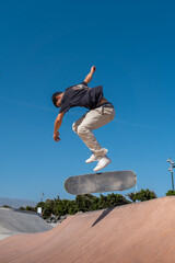 young skater wearing black tshirt skating  in a skate park in a sunny day © magui RF
