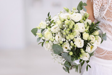Bride with beautiful wedding bouquet on light background, closeup. Space for text