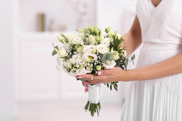 Bride with beautiful wedding bouquet on light background, closeup. Space for text