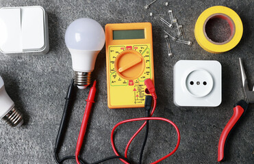 Different electrical tools on grey table, flat lay