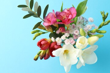 Bouquet of beautiful flowers on light blue background, top view
