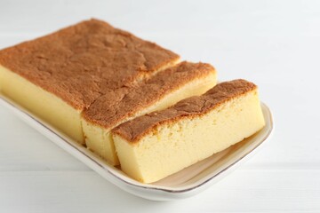 Tasty Japanese Castella sponge cake on white wooden table, closeup