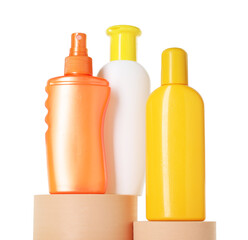 Different sun protection products on podiums against white background