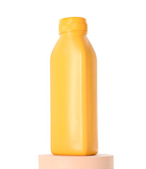 Bottle of sun protection product on podium against white background