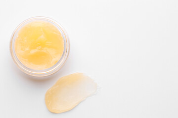 Jar and sample of lip balm on white background, top view. Space for text