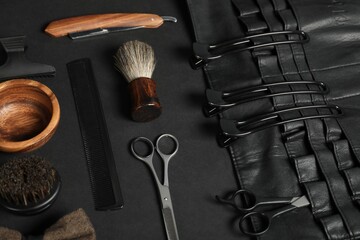 Many different barber's tools on black table, above view