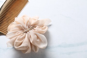 Beautiful hair clip and comb on white marble table, closeup. Space for text